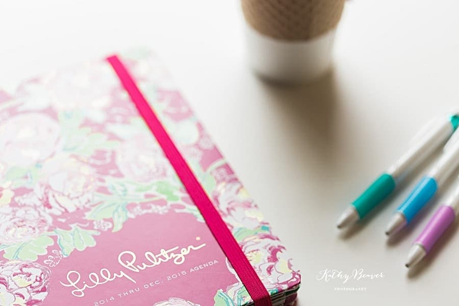 Pink lilly pulitzer agenda with pens and coffee cup