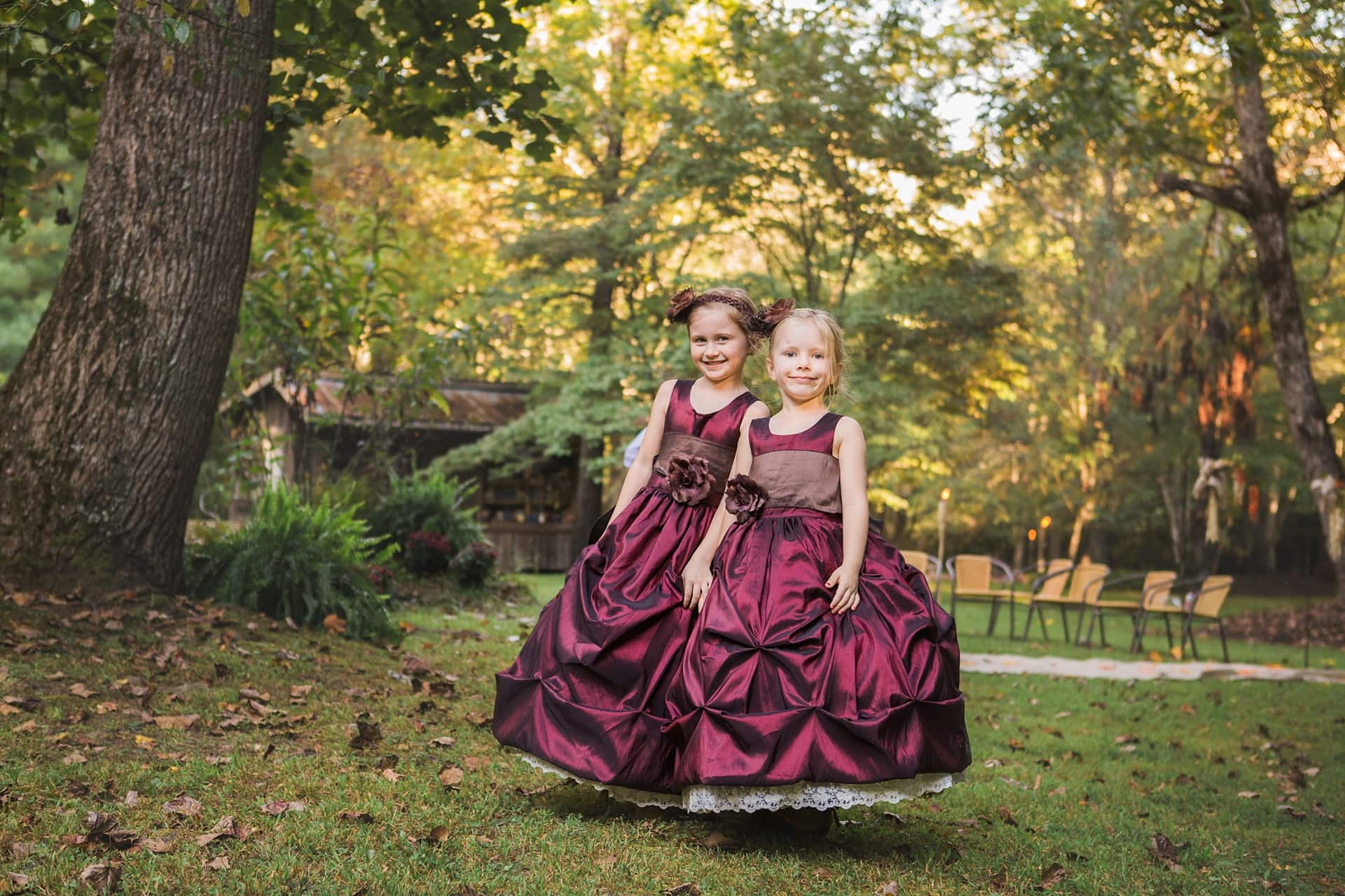 Two sisters in fall burgundy dresses in rural area