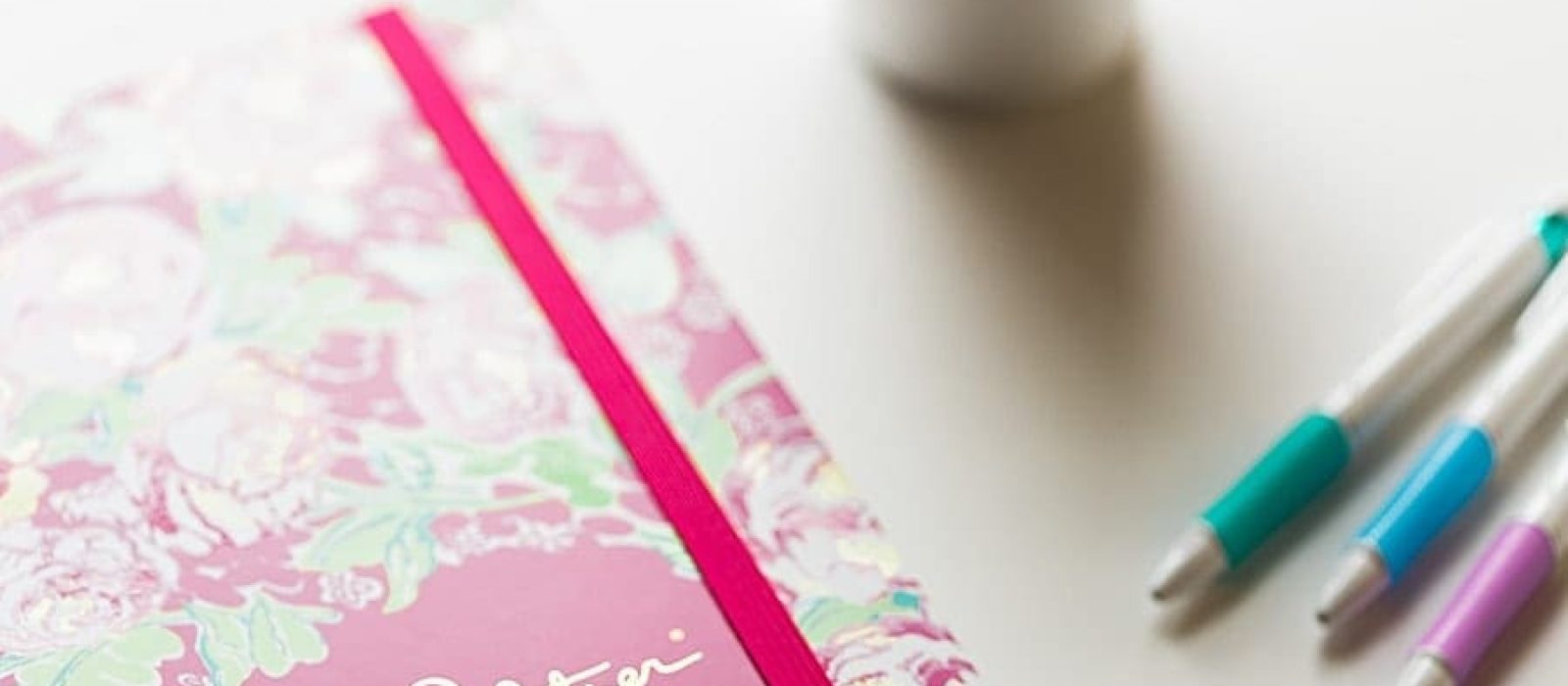 Pink lilly pulitzer high school agenda with pens and coffee cup